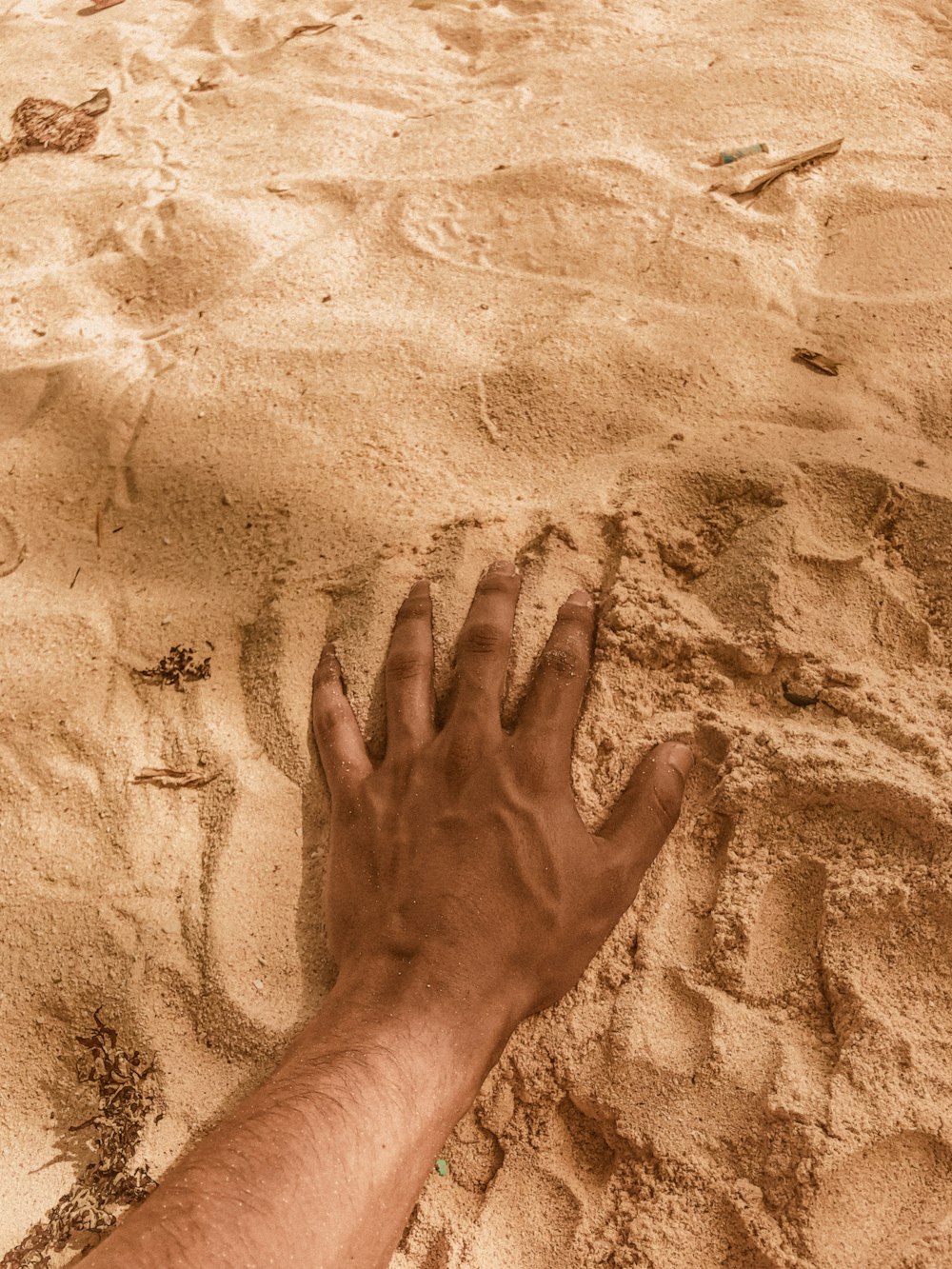 persons left hand on brown sand