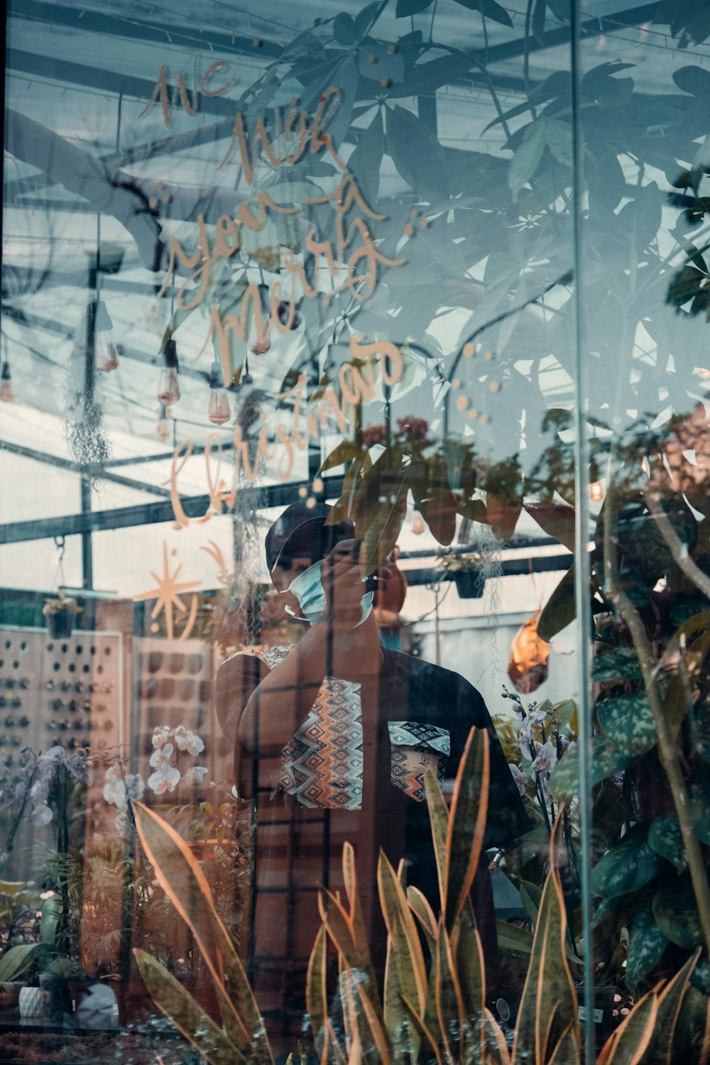 woman in black and brown dress standing in front of green plants