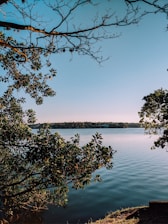 A serene view of Mayfair Lake Resort surrounded by lush greenery and calm waters under a clear sky.