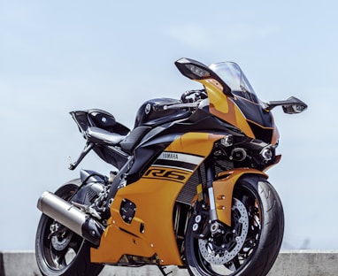 orange and black sports bike parked on gray concrete pavement during daytime