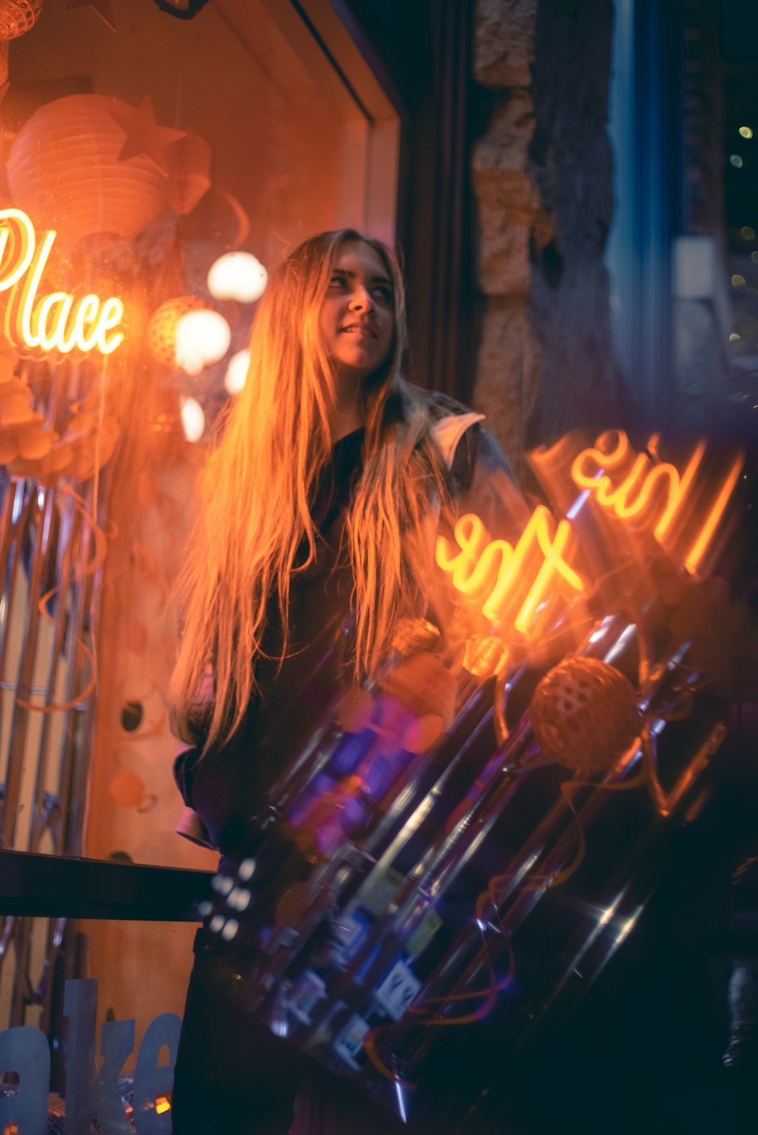 woman in gray jacket standing near lighted candles