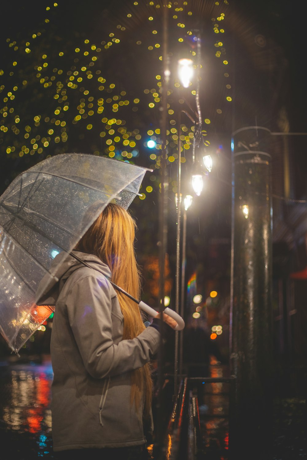 woman in gray coat holding umbrella