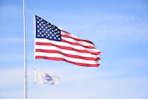 white and red flag on pole under blue sky during daytime