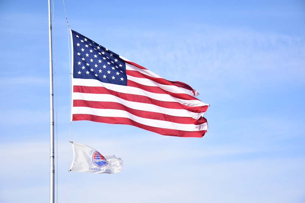 white and red flag on pole under blue sky during daytime