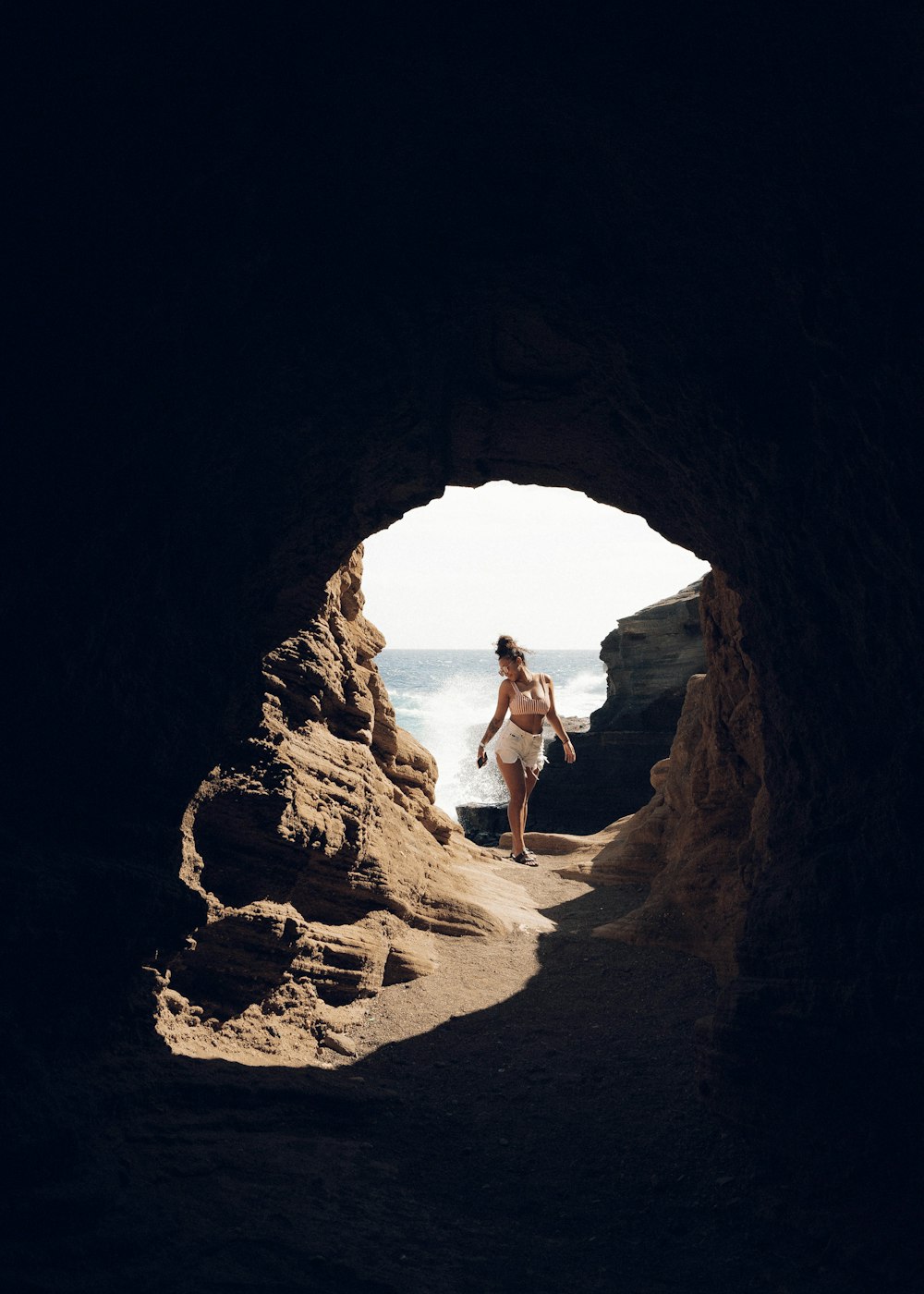 Mujer en vestido blanco de pie en la formación rocosa marrón durante el día