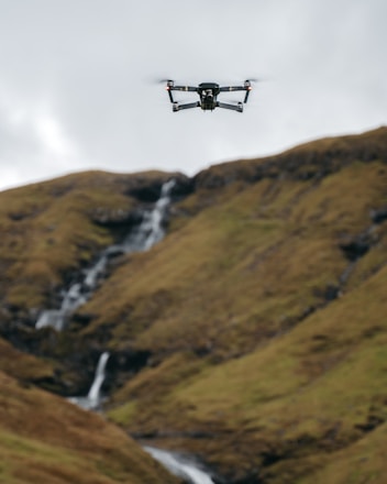 A drone delivering emergency supplies over a flood-affected village at dawn.