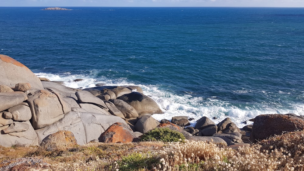 Rocas marrones cerca del cuerpo de agua durante el día