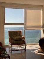 Sunlight streaming through a window onto a cozy coastal-inspired reading nook.