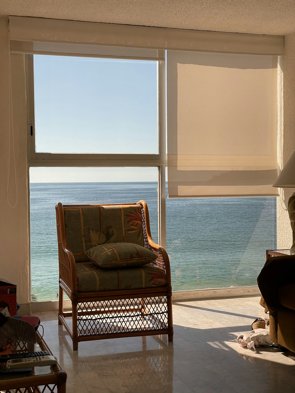 brown wooden framed padded armchair near window