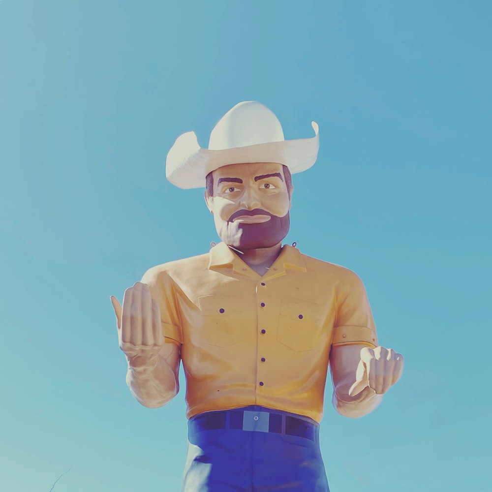 homem na camisa do vestido amarelo vestindo o chapéu branco do cowboy