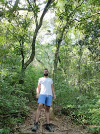 A mature man confidently hiking in a lush forest, symbolizing vitality and connection to nature.
