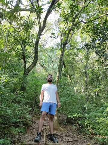 A mature man confidently hiking in a lush forest, symbolizing vitality and connection to nature.