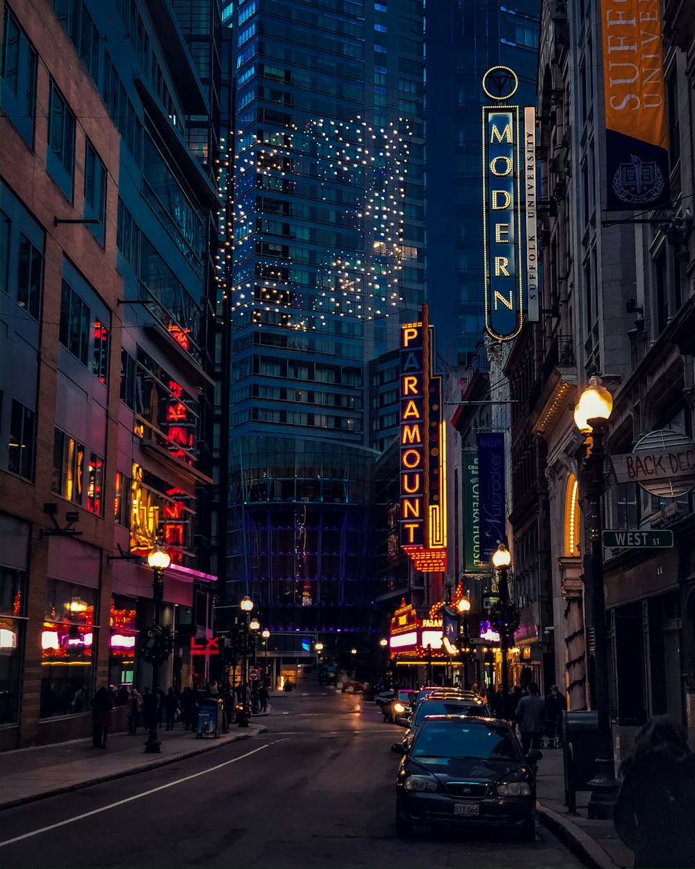 carros na estrada entre edifícios altos durante a noite