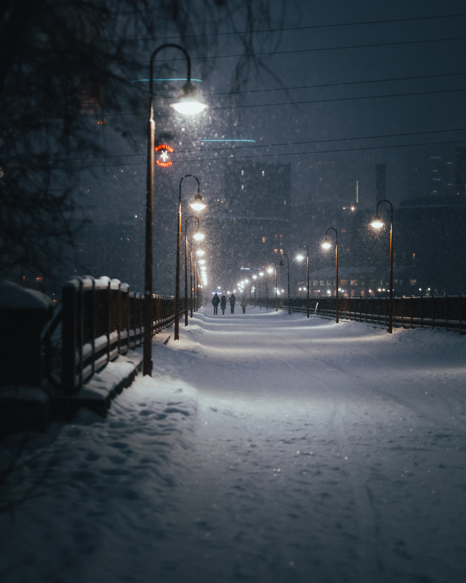 An empty road under deep snow at night, the surface blue-grey in the dark