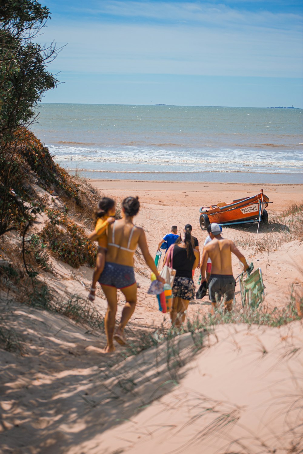 a group of people walking down a sandy beach