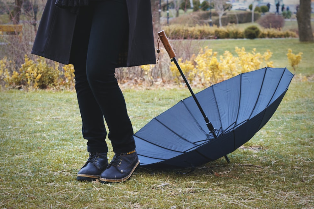 a person standing in a field holding an umbrella