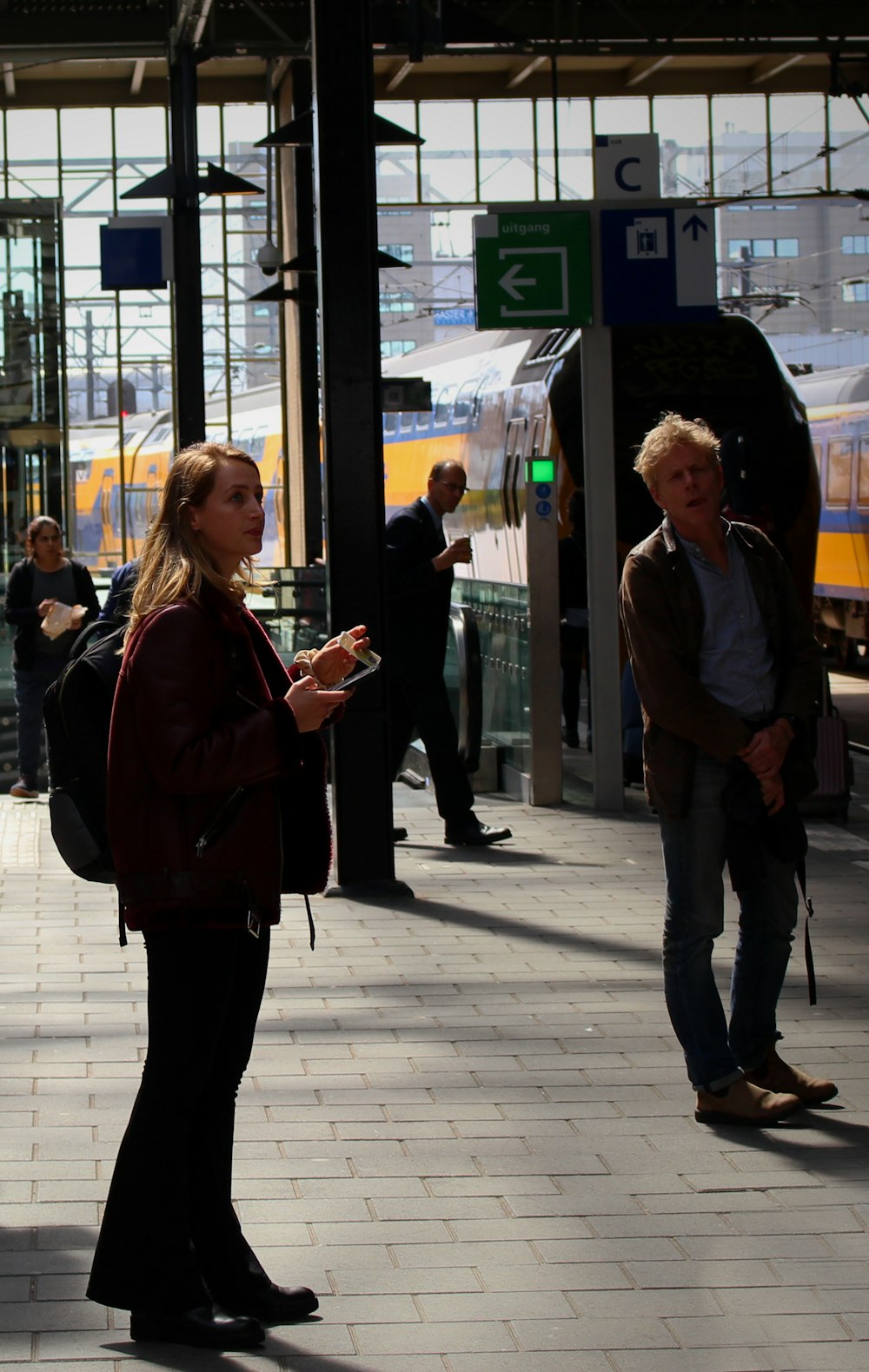 woman in black jacket standing beside man in blue shirt