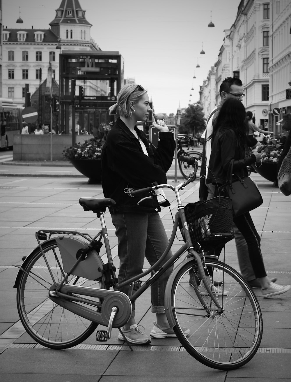 grayscale photo of woman in black jacket and pants riding on bicycle