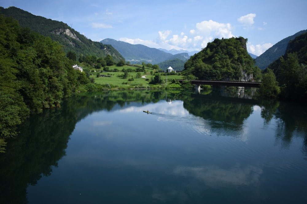 green trees on mountain beside lake during daytime