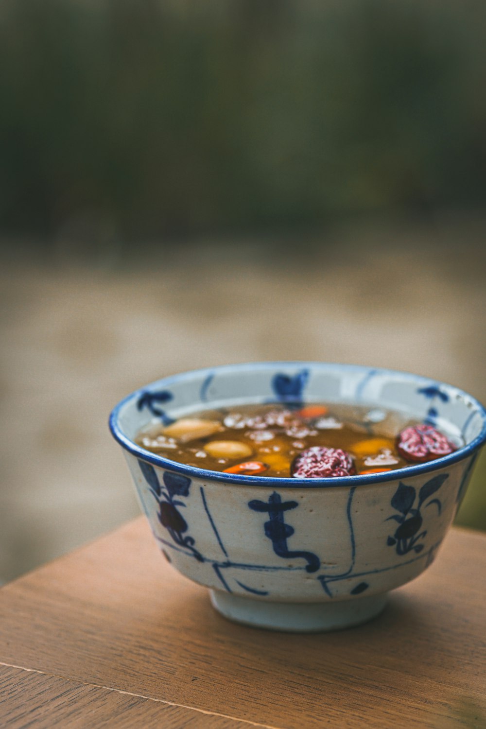 white and blue ceramic bowl with orange and yellow liquid