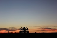 A sunset view of an outdoor art exhibit featuring sculptures and paintings from African diaspora artists.