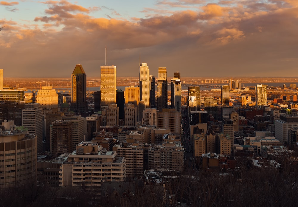 city skyline under orange and gray cloudy sky during sunset