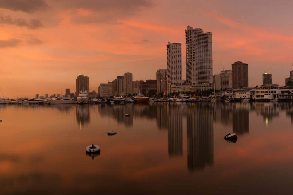 white boat on water near city buildings during sunset