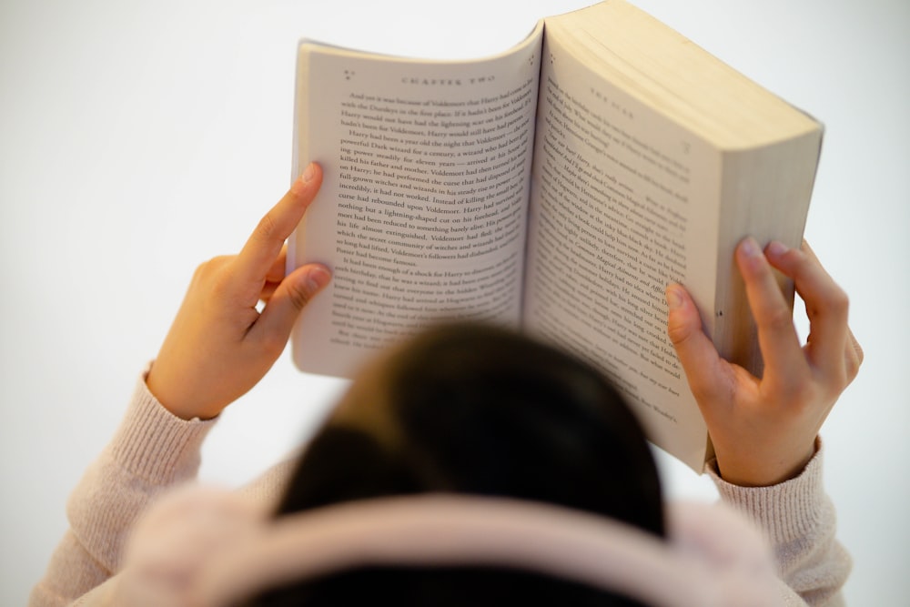 woman in white long sleeve shirt reading book