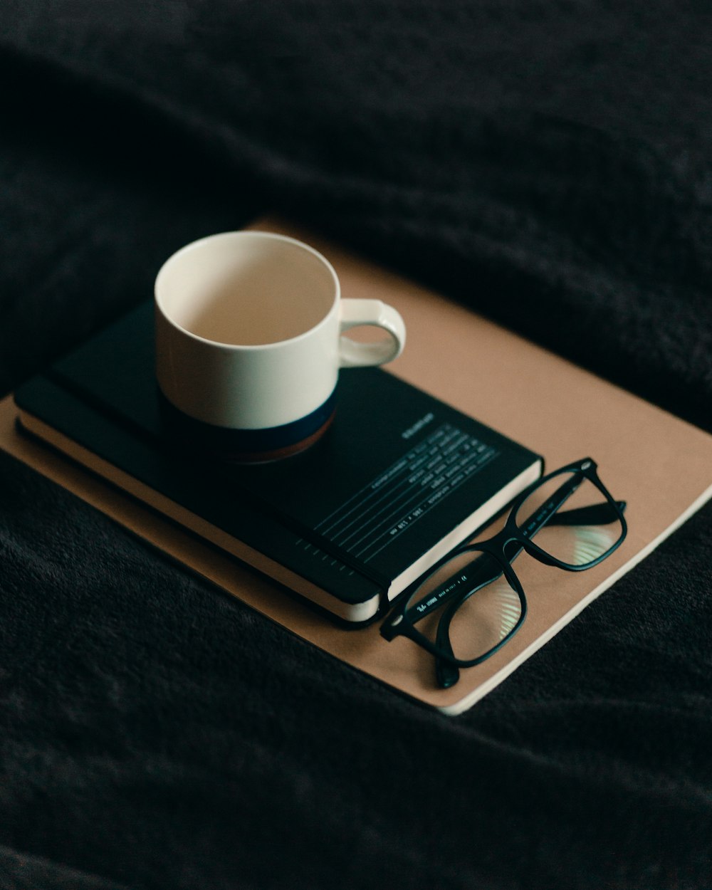 white ceramic mug on brown book