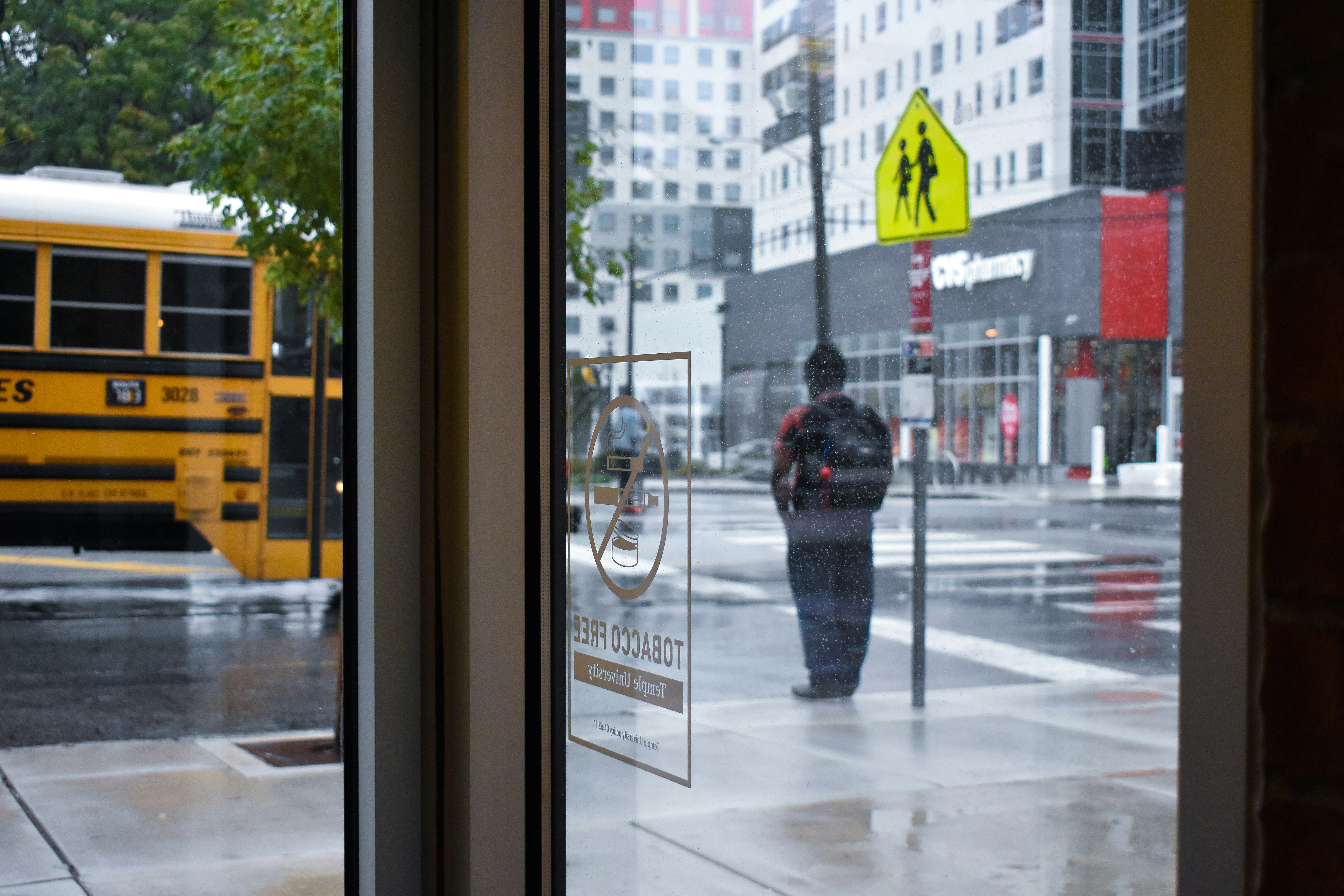 person in black jacket standing in front of glass window