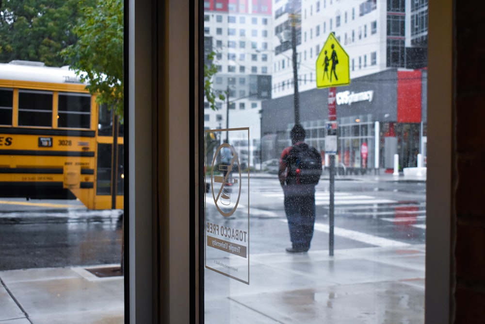 person in black jacket standing in front of glass window