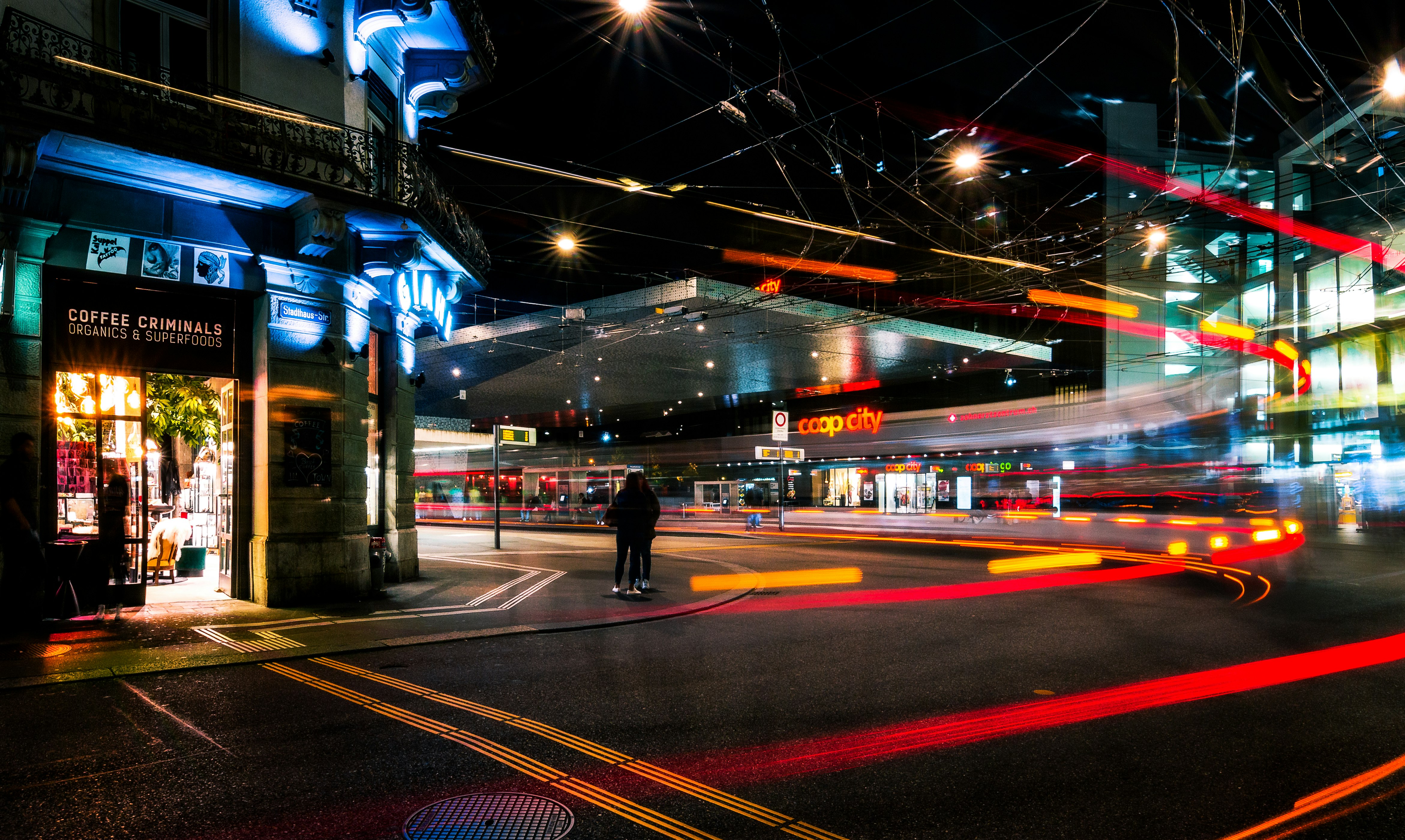 man in black jacket walking on sidewalk during night time