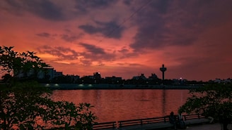 Sunset view over Toledo's downtown skyline with the Maumee River reflecting orange hues.