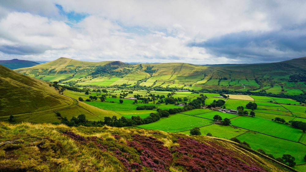 green grass field under cloudy sky during daytime