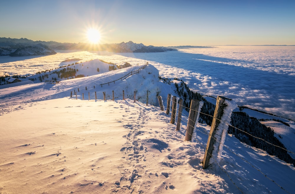 昼間は白い雪に覆われた地面に茶色の木製の柵