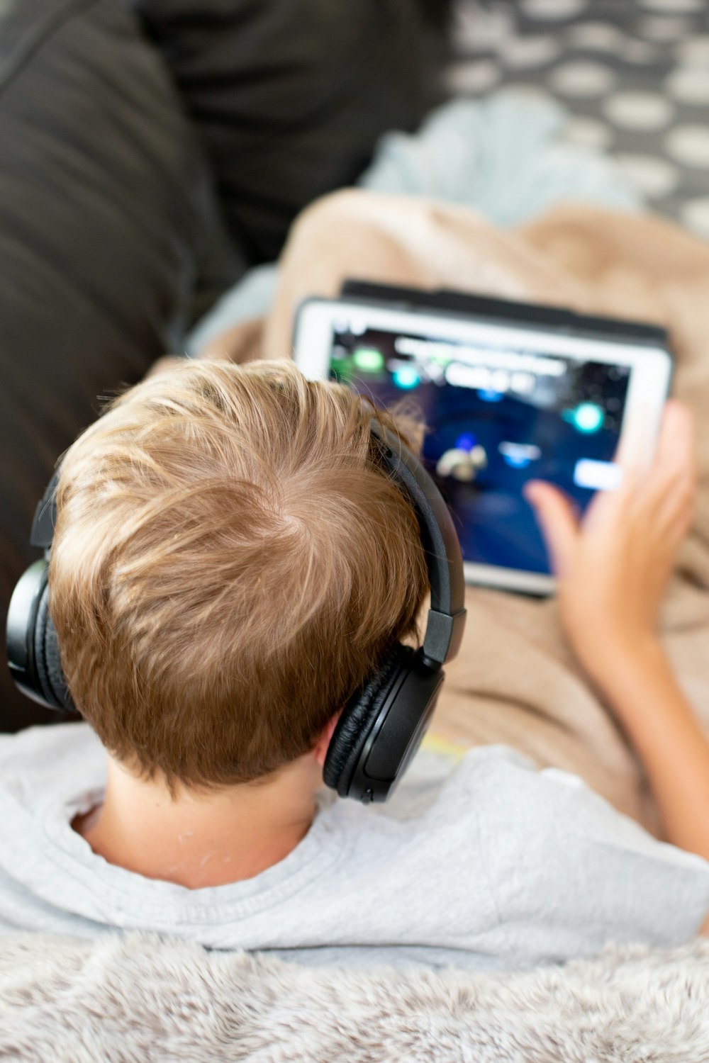 boy in white shirt using white tablet computer