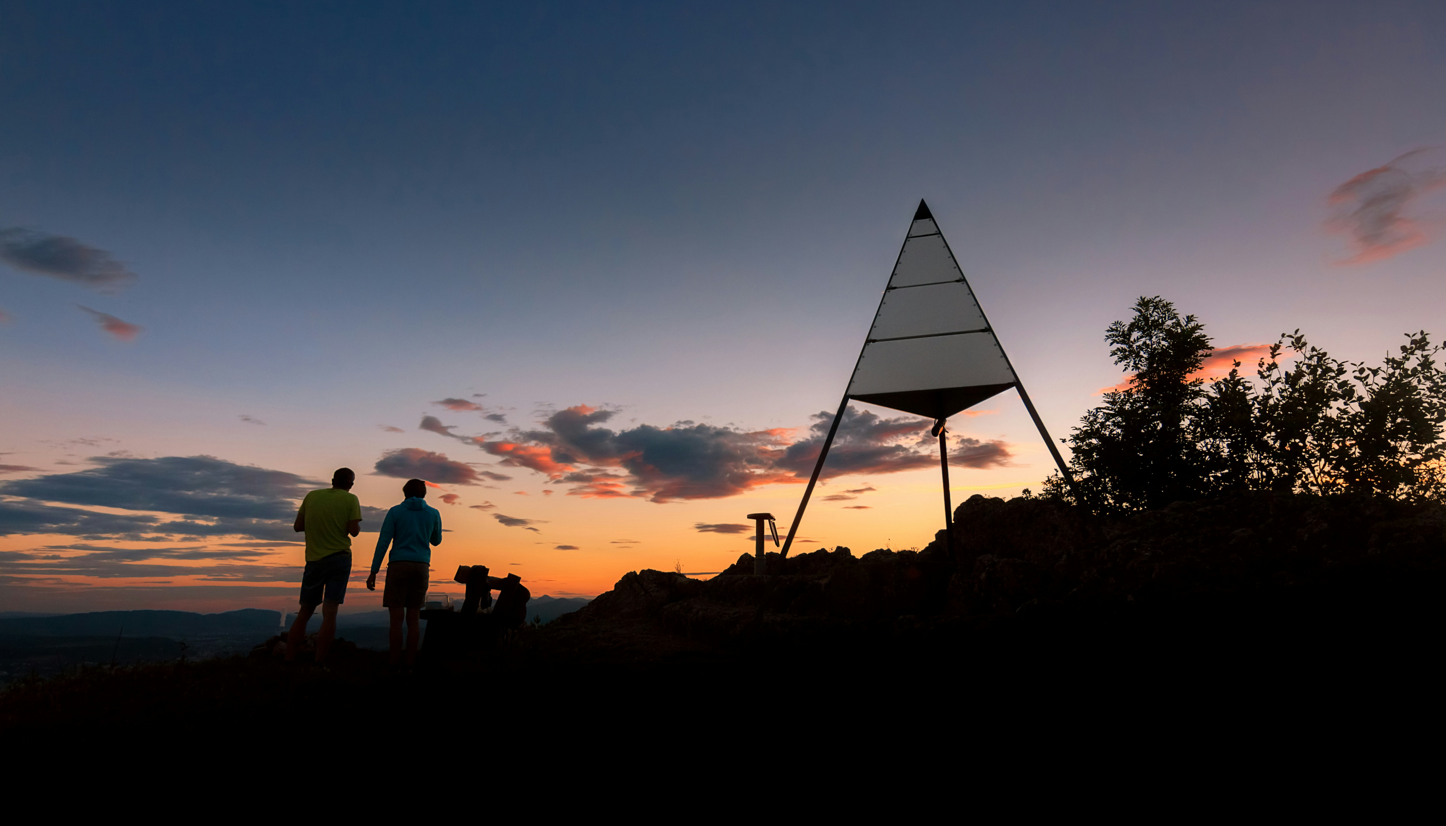 silhouette of people standing on mountain during sunset
