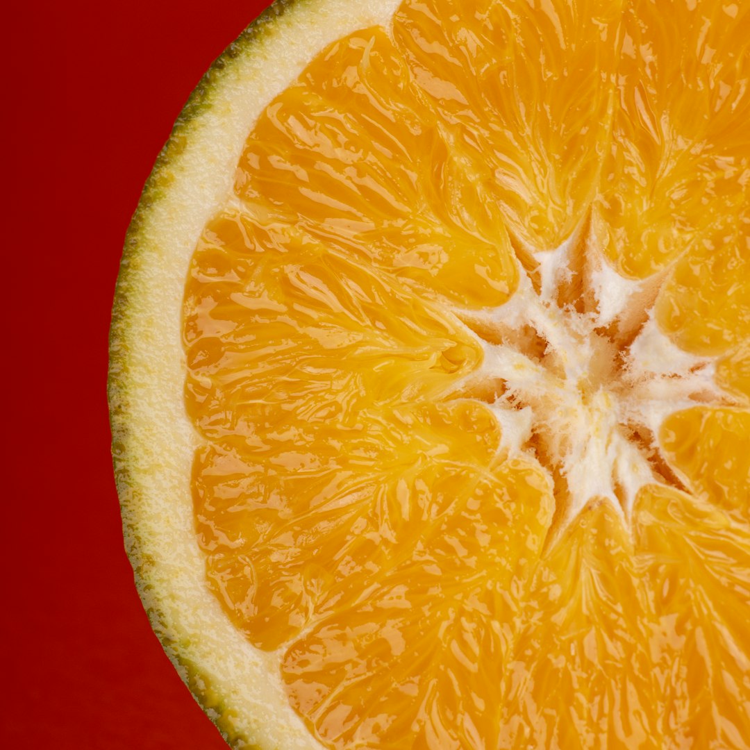 sliced orange fruit on red textile