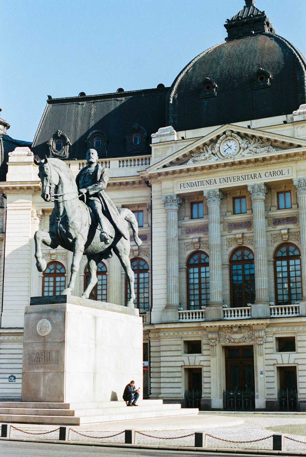 Estatua del caballo blanco frente al edificio de hormigón blanco durante el día