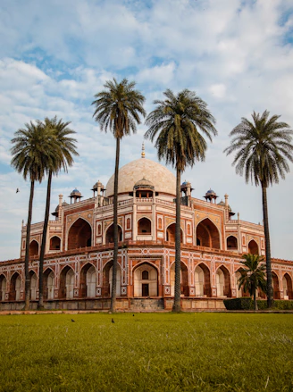 brown concrete building near palm trees during daytime