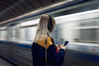 woman in black jacket holding smartphone