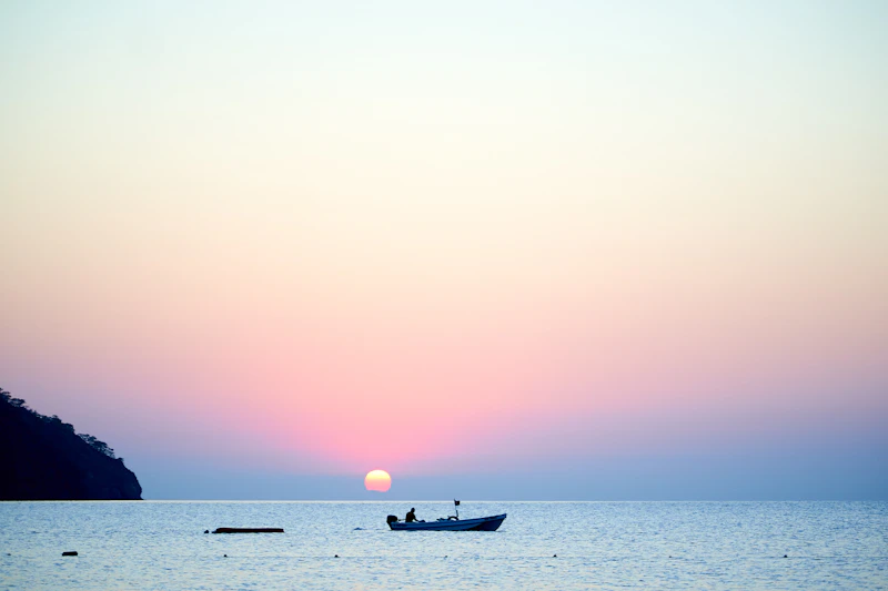 Silhouette of a traditional dhow boat sailing during sunset off Zanzibar