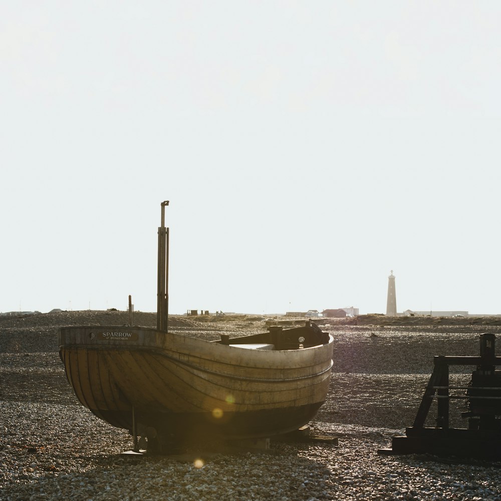 brown and white boat on sea shore during daytime