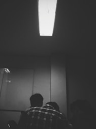 Group of focused individuals in a dimly lit room brainstorming over a glowing table.