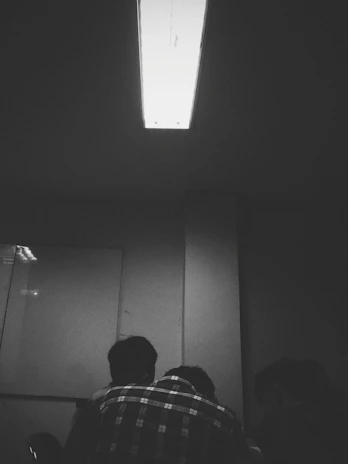 A focused group of traders discussing charts and strategies in a modern, dark-themed room.