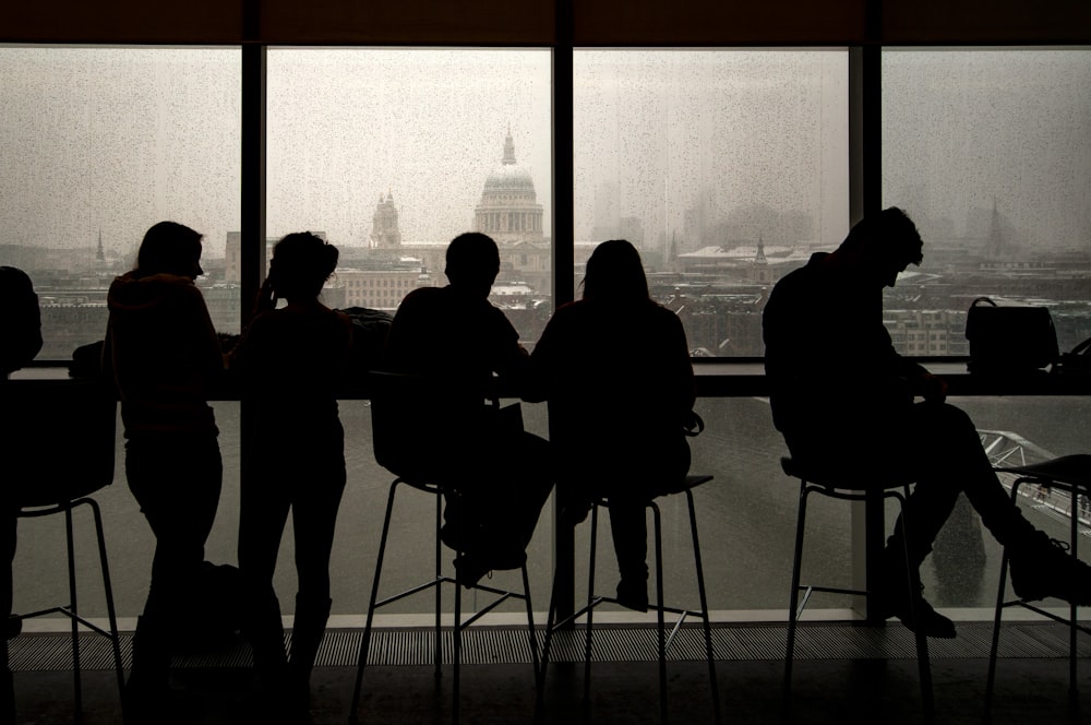 silhouette of people standing near window