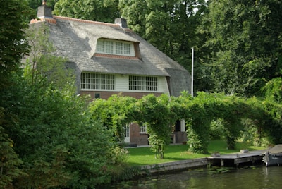 Charming cottage surrounded by lush greenery and flowers.