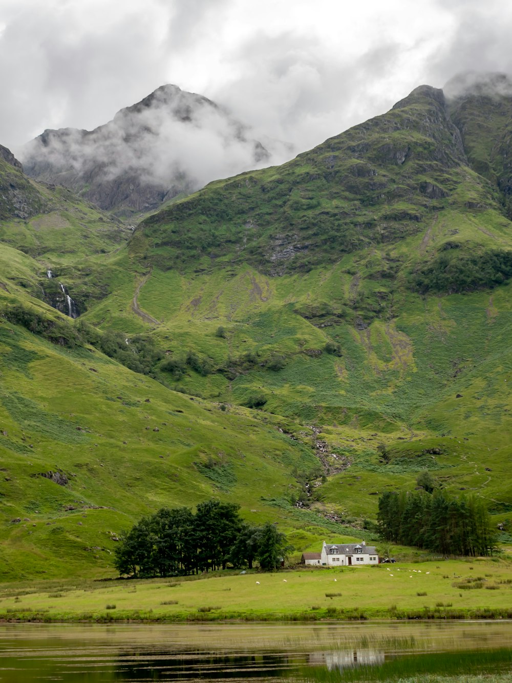 montagnes vertes sous des nuages blancs pendant la journée