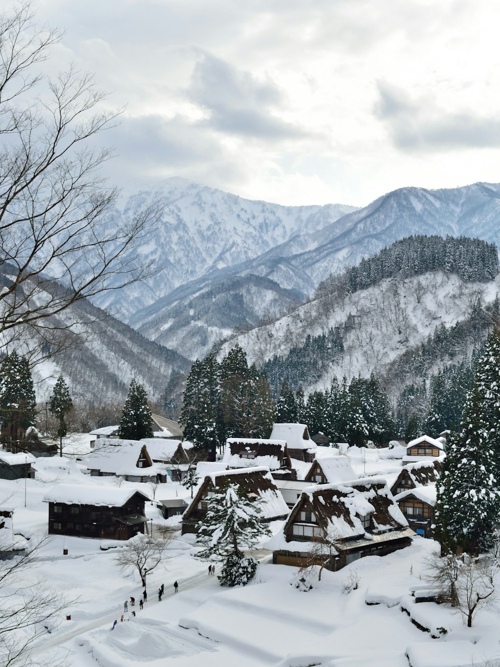 houses on snow covered ground near mountain during daytime