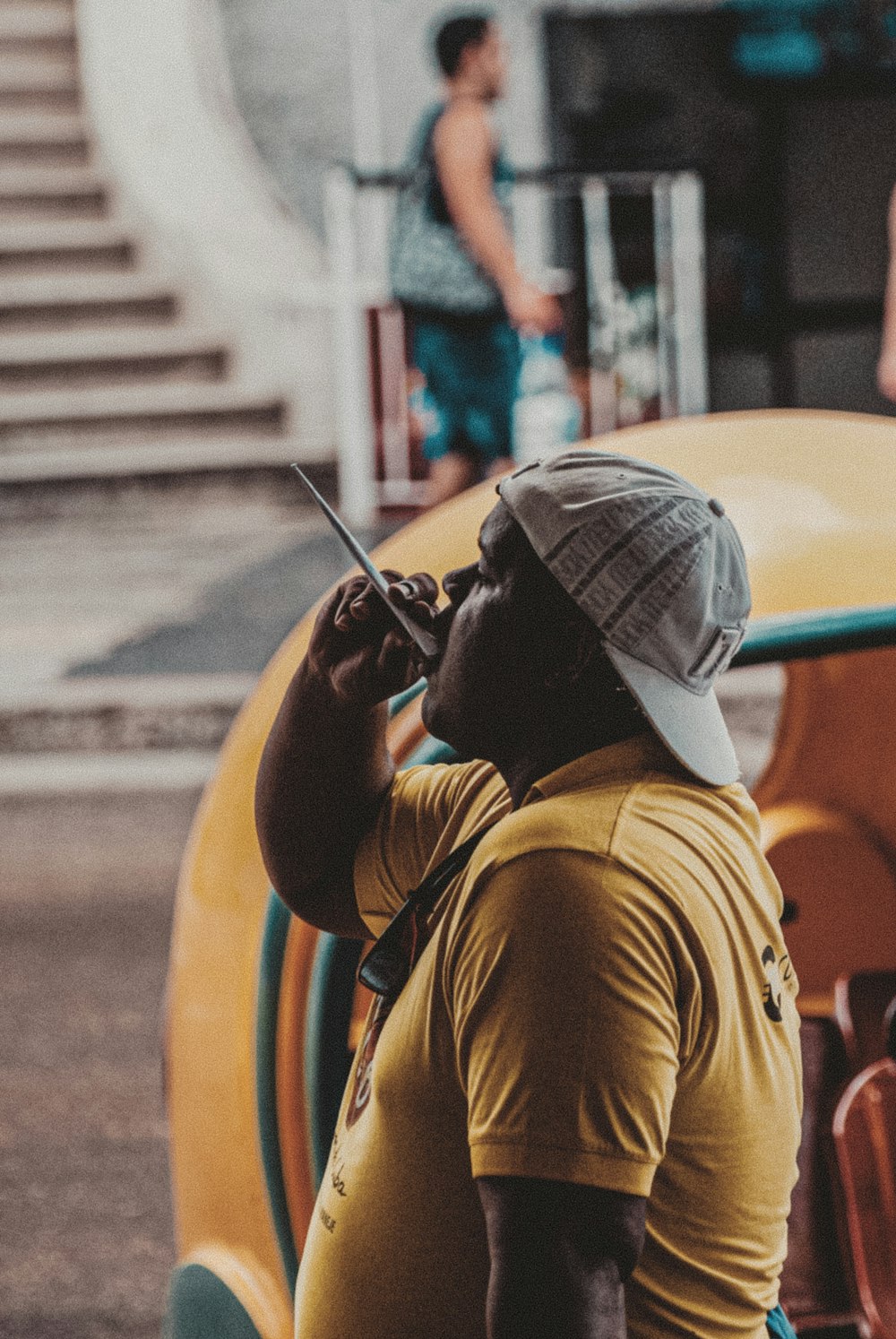 man in brown shirt and gray cap using dslr camera